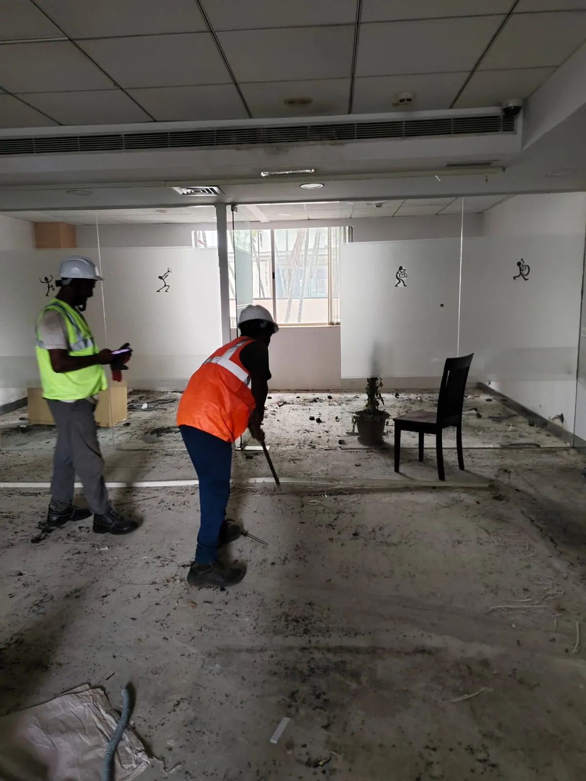 Deconstruction technicians dismantling linear workspace frames safely inside a high-rise office building along OMR Chennai.